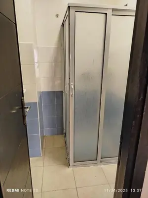 a bathroom with a shower with a sliding glass door at appartement martil in Oulad Akkou