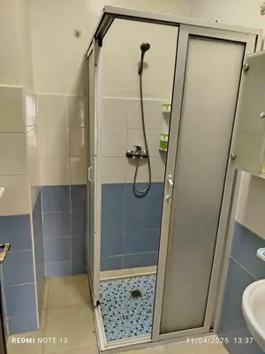 a shower with a glass door in a bathroom at appartement martil in Oulad Akkou