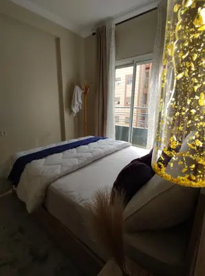 a bedroom with a bed with a christmas tree next to a window at Diar kamiliya in Meknès