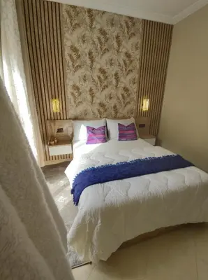 a bedroom with a large bed with purple pillows at Diar kamiliya in Meknès