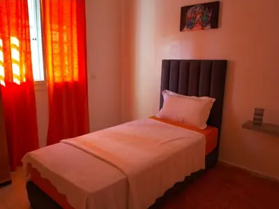 a bed in a bedroom with red curtains at Appartement la perle in Fès