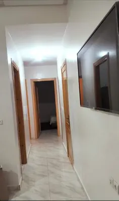 a hallway with a flat screen tv on a wall at Appartement la perle in Fès