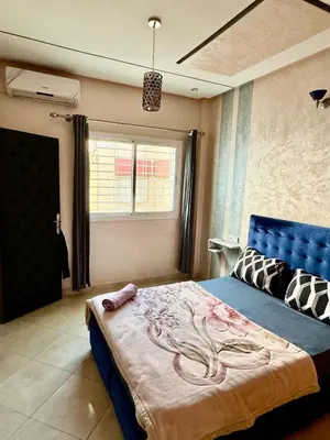 a bedroom with a blue bed and a window at Appartement F in Fès
