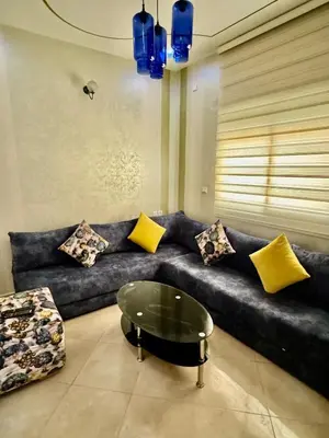 a living room with a blue couch with yellow pillows at Appartement F in Fès