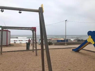 a playground on the beach with the ocean in the background at Beautiful villa with large private pool in Zaouia Sidi Rahkal