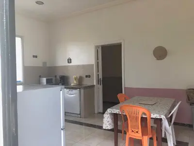 a kitchen with a table and chairs and a kitchen with a refrigerator at Beautiful villa with large private pool in Zaouia Sidi Rahkal