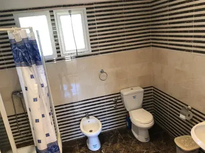 a bathroom with a toilet and a sink at Beautiful villa with large private pool in Zaouia Sidi Rahkal