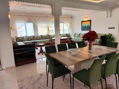 a dining room with a wooden table and green chairs at villa saada in Fès