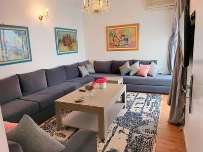 a living room with a blue couch and a table at villa saada in Fès