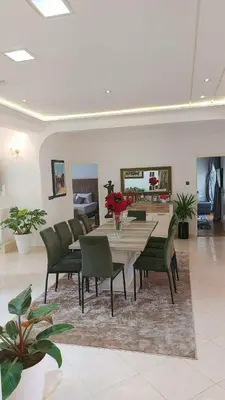 a dining room with a table and green chairs at villa saada in Fès