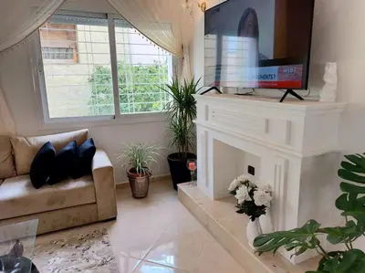 a living room with a fireplace and a flat screen tv at villa saada in Fès