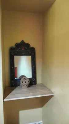 a mirror sitting on a shelf in a room at Kasbat Taslit chez l'habitant in Tabount