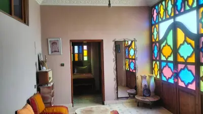 a living room with a colorful stained glass wall at Kasbat Taslit chez l'habitant in Tabount