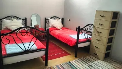 a bedroom with two beds and a dresser at Kasbat Taslit chez l'habitant in Tabount