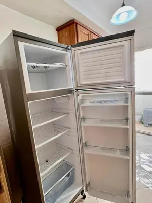 an empty refrigerator with its door open in a kitchen at nice apaprt in Oulad Akkou