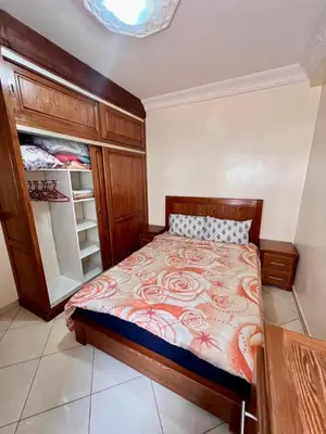 a bedroom with a bed and an open closet at nice apaprt in Oulad Akkou