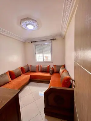 a living room with a couch and a window at nice apaprt in Oulad Akkou