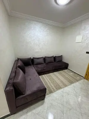 a living room with a brown couch in a room at Al khaima in Oulad Akkou