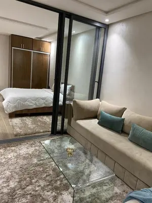 a living room with a couch and a bed at Duplex in Oulad Akkou
