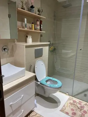 a bathroom with a toilet and a glass shower at Duplex in Oulad Akkou