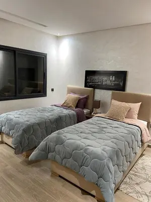 a bedroom with two beds and a large window at Duplex in Oulad Akkou