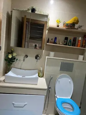 a bathroom with a blue toilet and a sink at Duplex in Oulad Akkou