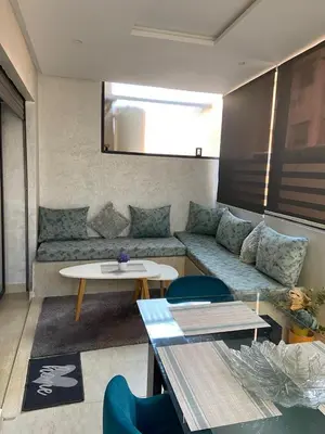 a living room with a couch and a table at Duplex in Oulad Akkou