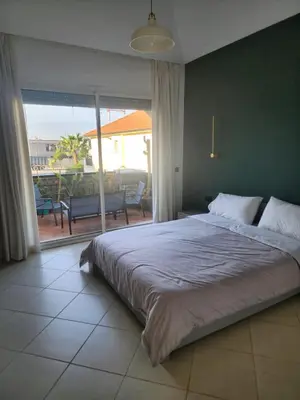 a bedroom with a large bed and a large window at Azure's House in Fès