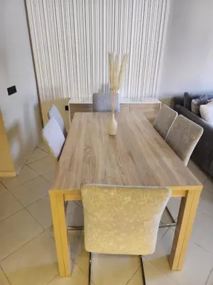 a wooden dining table with chairs and a vase on it at Azure's House in Fès