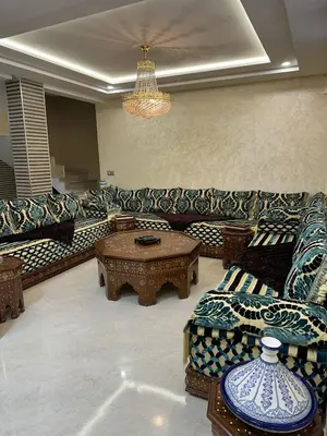 a living room with a couch and a table at apartamente á fes in Fès