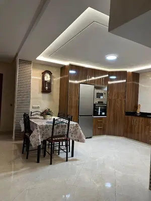 a kitchen with a table with chairs and a refrigerator at apartamente á fes in Fès