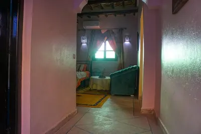 a hallway with a room with a table and a window at Lamtounipalace in Ouarzazate