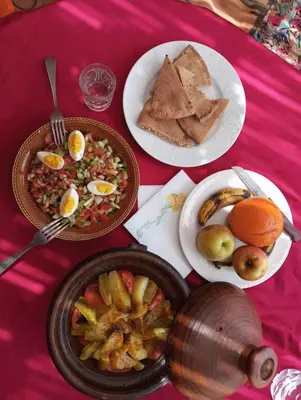 a table with plates of food on a pink table at Sahara Luxury Room and Tours in Kasr Bounou