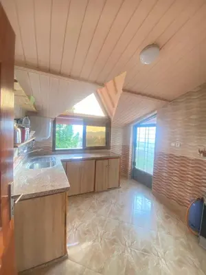 a large kitchen with wooden cabinets and a window at Espace vert Chalet familial à Azrou in Azrou