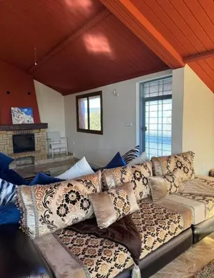 a living room with a couch with pillows on it at Espace vert Chalet familial à Azrou in Azrou