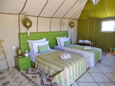 a bedroom with two beds in a tent at Your Desert Stay in Merzouga