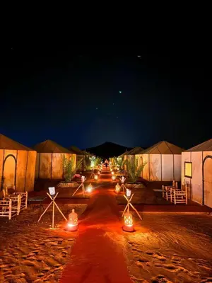 a group of tents with lights at night at Your Desert Stay in Merzouga