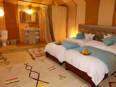 a bedroom with two beds with kites on the floor at Your Desert Stay in Merzouga