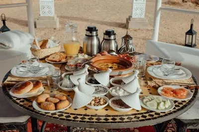 a table topped with plates of food on a table at Your Desert Stay in Merzouga