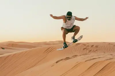 a man riding a snowboard on top of a sand dune at Your Desert Stay in Merzouga