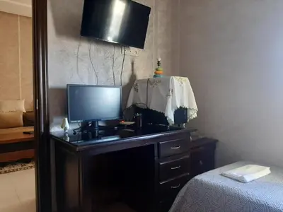 a bedroom with a television on a dresser with a bed at Chambre d'hôte jardins de Hamria in Meknès
