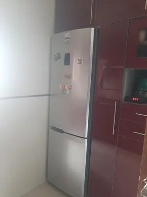 a white refrigerator in a kitchen next to a red cabinet at Chambre d'hôte jardins de Hamria in Meknès
