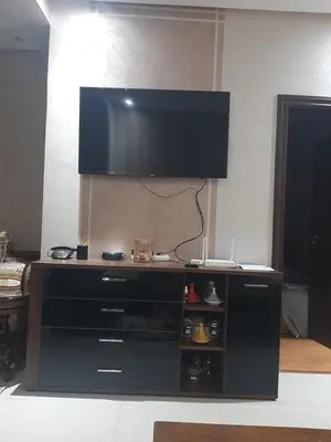 a entertainment center with a flat screen tv on top at Chambre d'hôte jardins de Hamria in Meknès