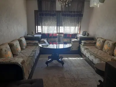 a living room with couches and a table in the middle at Chambre d'hôte jardins de Hamria in Meknès