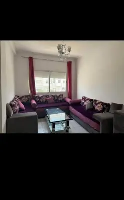 a living room with a purple couch and a table at Almaz in Fès