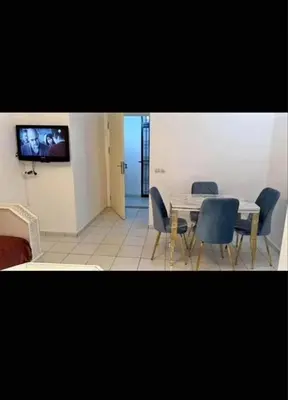 a dining room with a table and chairs and a tv at Almaz in Fès