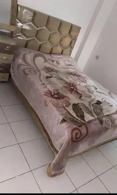 a bed with a blanket with flowers on it at Almaz in Fès
