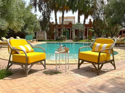 two chairs and a table in front of a pool at Palais Julia in Chouiter