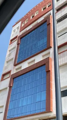 a tall brick building with blue glass windows at Apartment Ocean view in Oulad Akkou