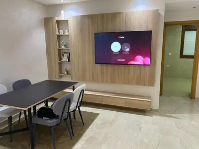 a dining room with a table and a tv on a wall at Apartment Ocean view in Oulad Akkou